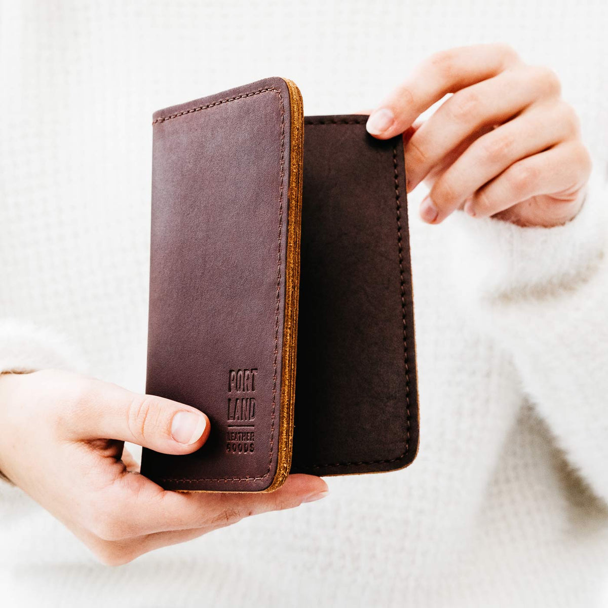 Cognac | Model holding leather passport case with PLG logo