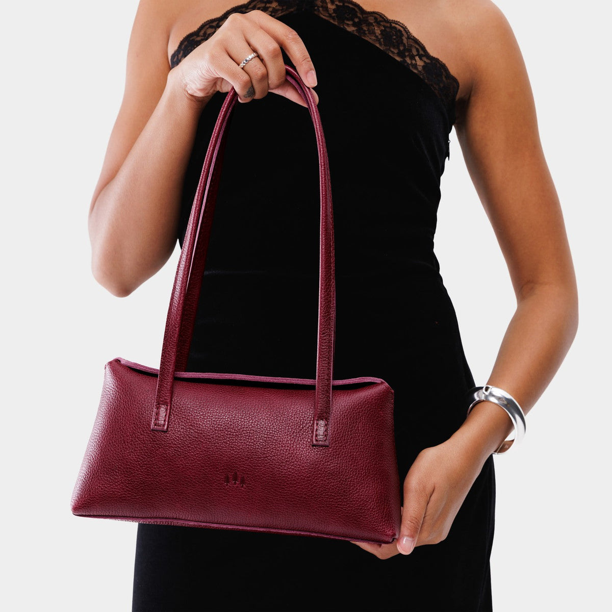 Orchid | Person holding leather bowler bag with magnetic closure