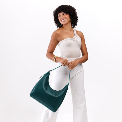 Sea Glass*Large | Model holding u-shaped, flat-bottomed leather shoulder bag with adjustable strap