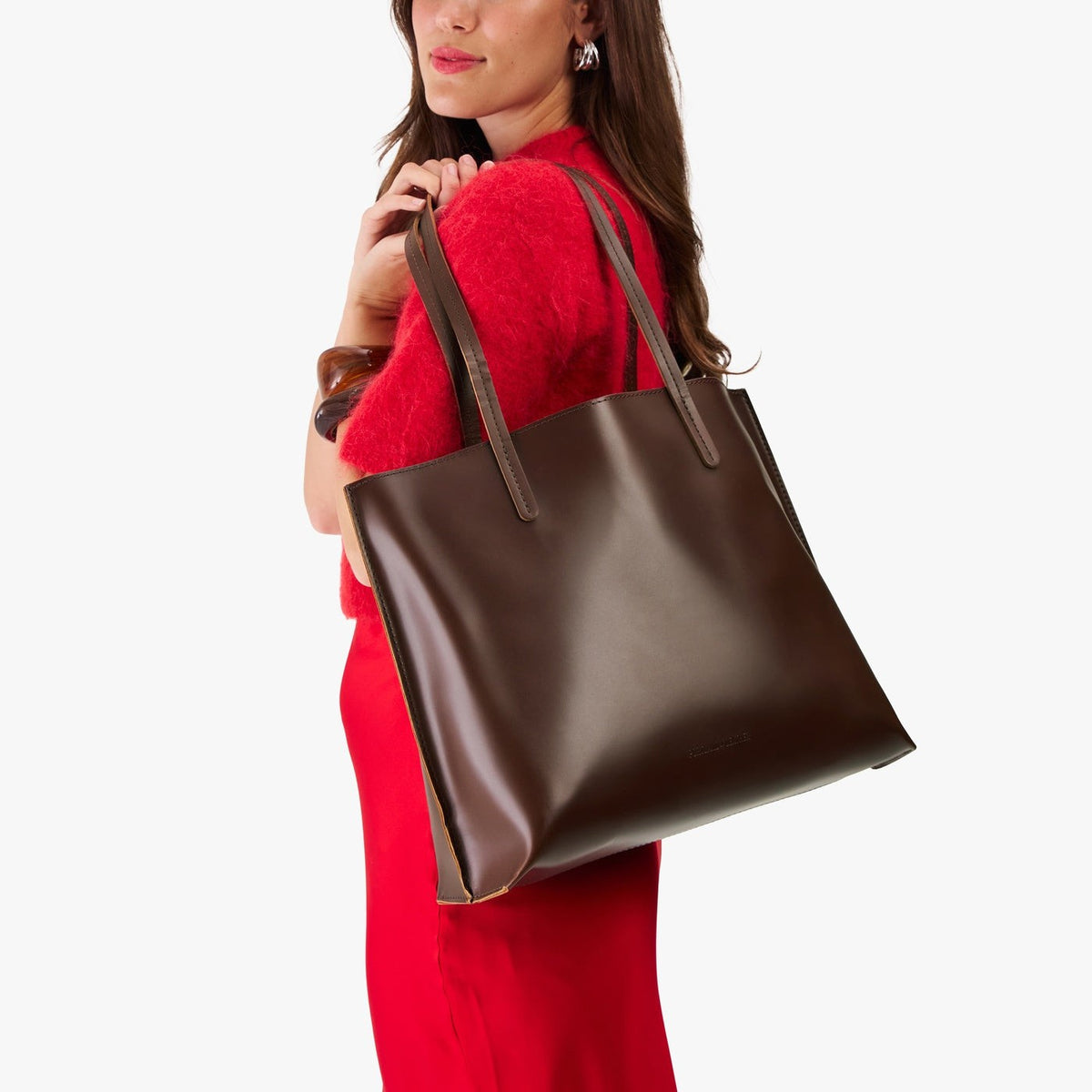 Chocolate Brown*Large | Model holding leather tote bag with interior snap key loop