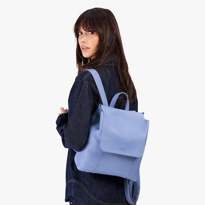 Aster | Model wearing a leather backpack on a white background