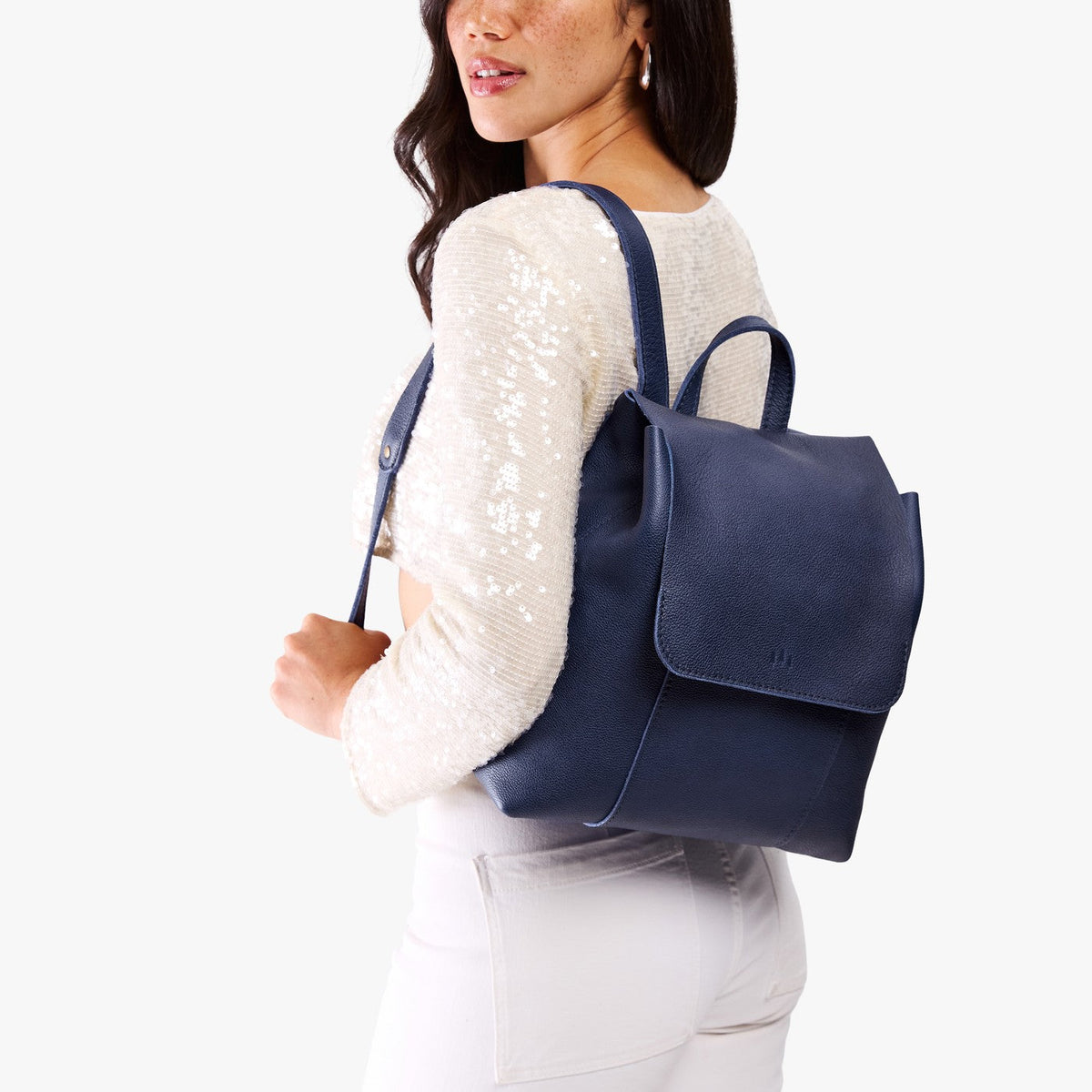 Cobalt | Model wearing a leather backpack on a white background