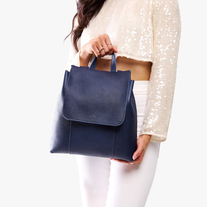 Cobalt | Model wearing a leather backpack on a white background