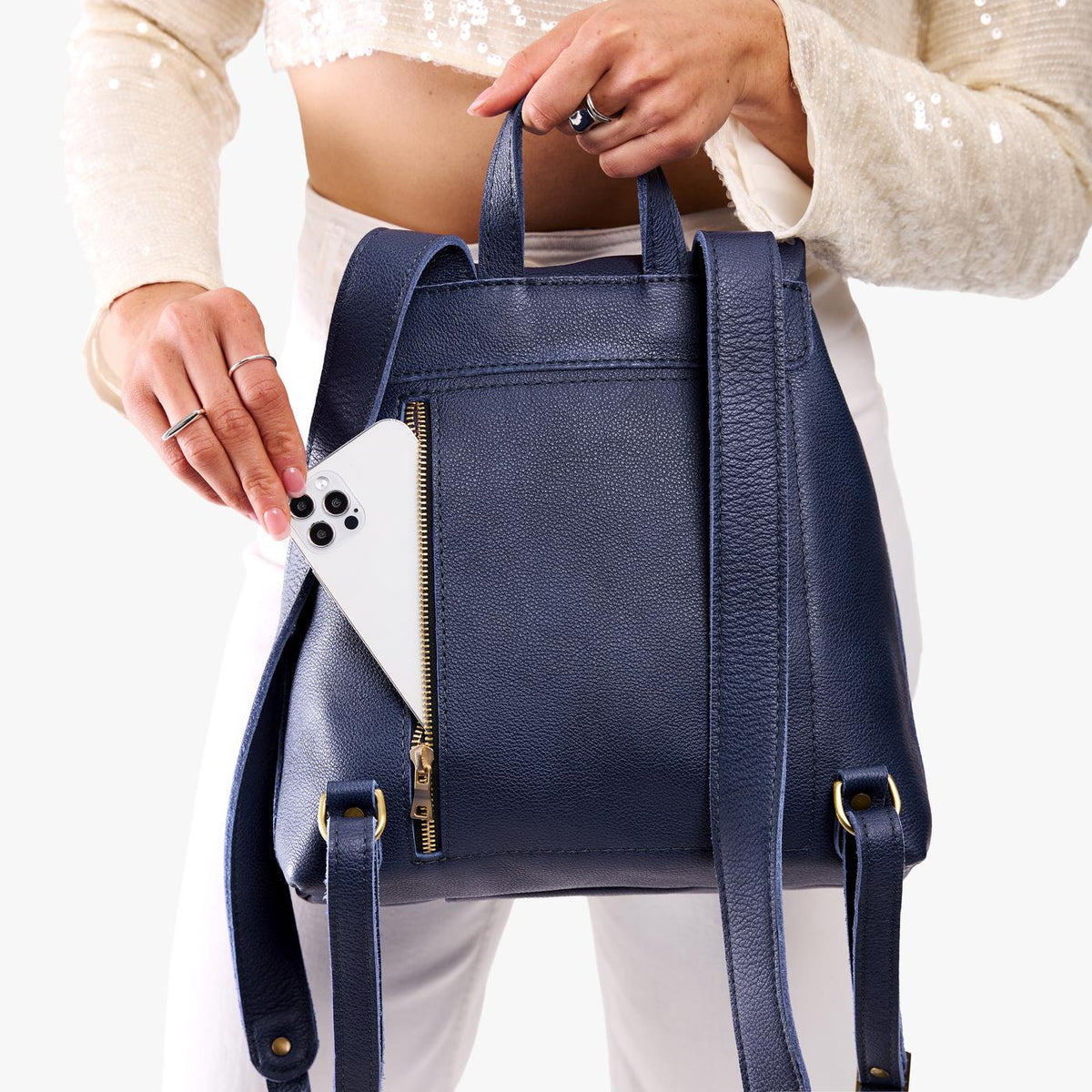 Cobalt | Model wearing a leather backpack on a white background