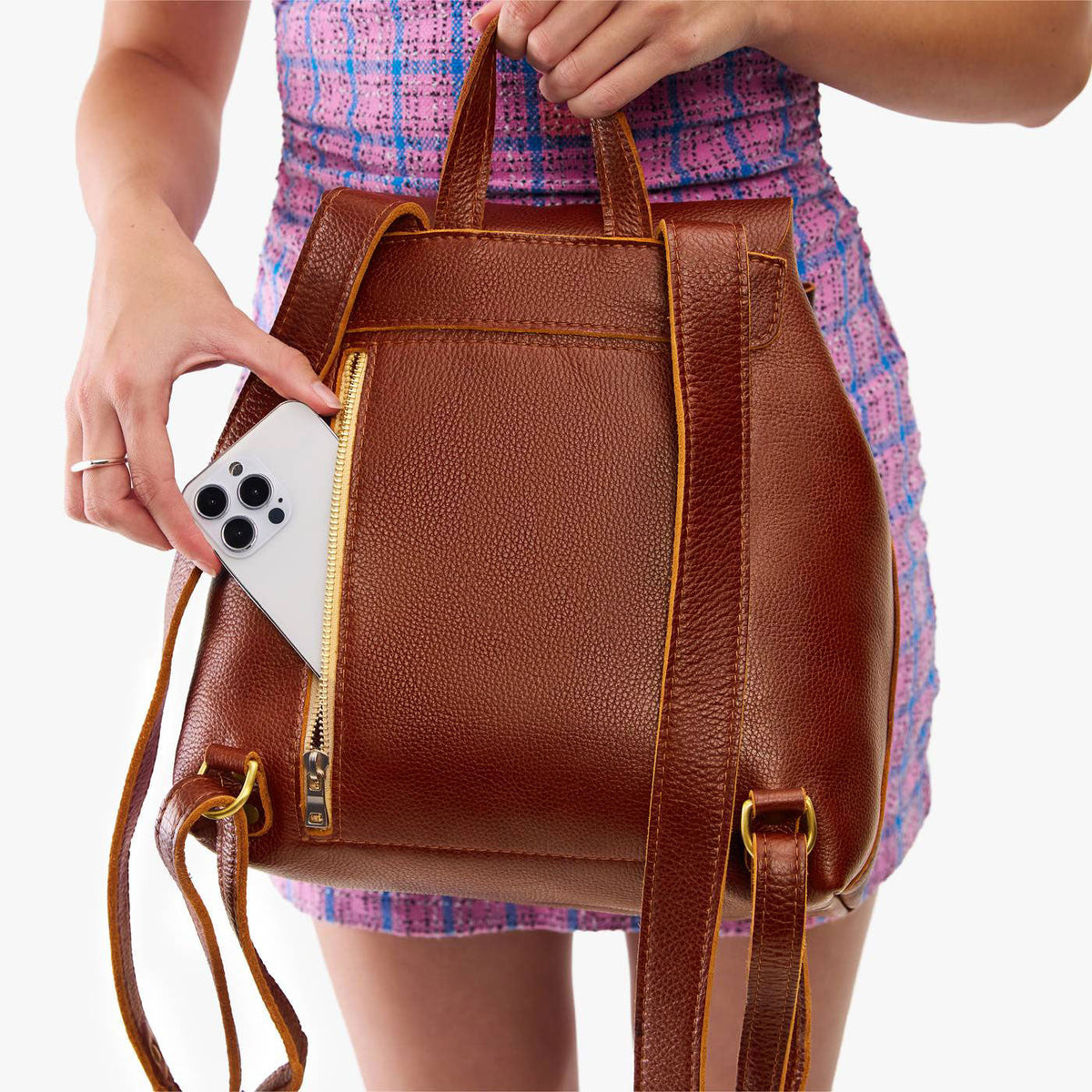 Nutmeg | Model wearing a leather backpack on a white background