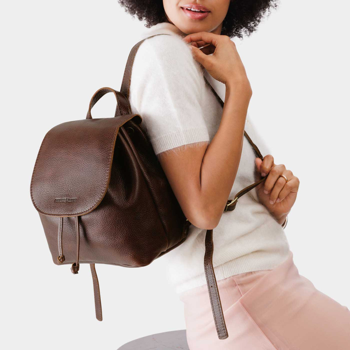 Coldbrew | Pebbled leather drawstring backpack being worn by a person.