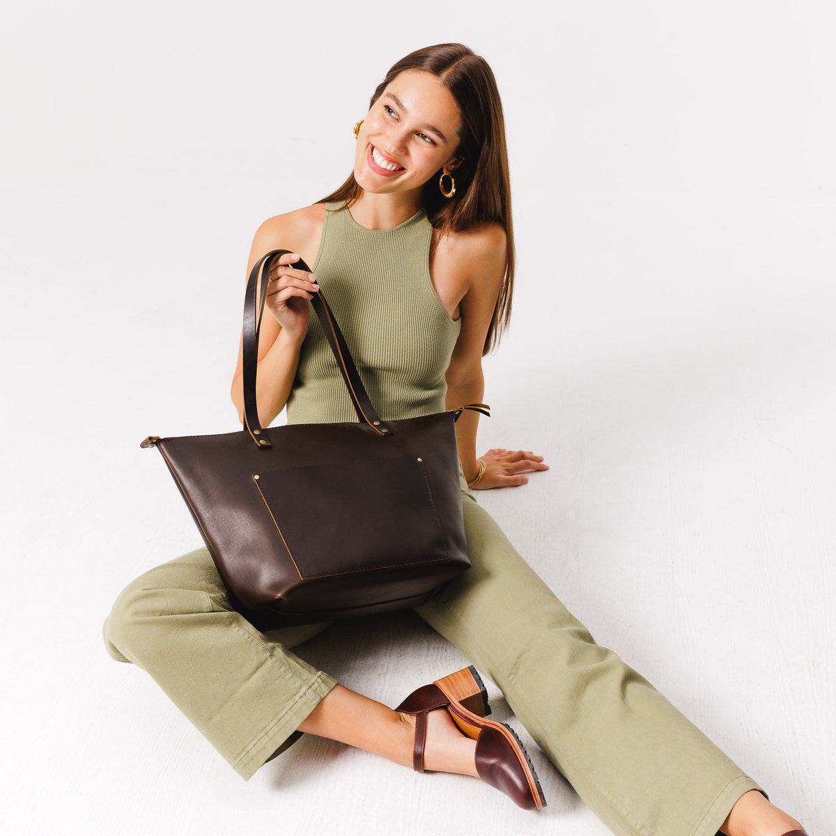 Grizzly*Zipper | Model holding large zipper leather tote bag with sturdy bridle handles and front pocket