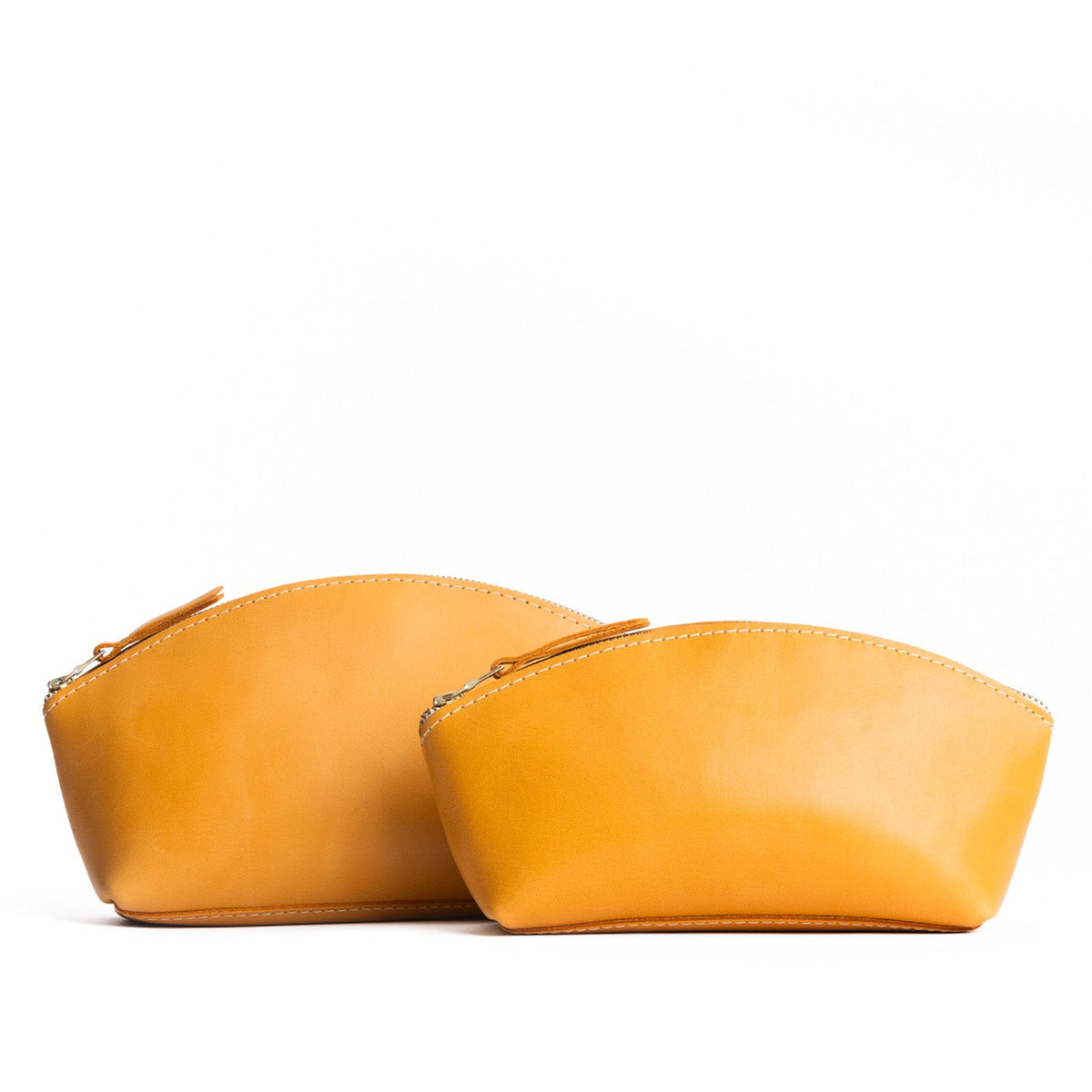 Sunflower | Size comparison shot of two spacious leather makeup bags with curved seams and top zipper