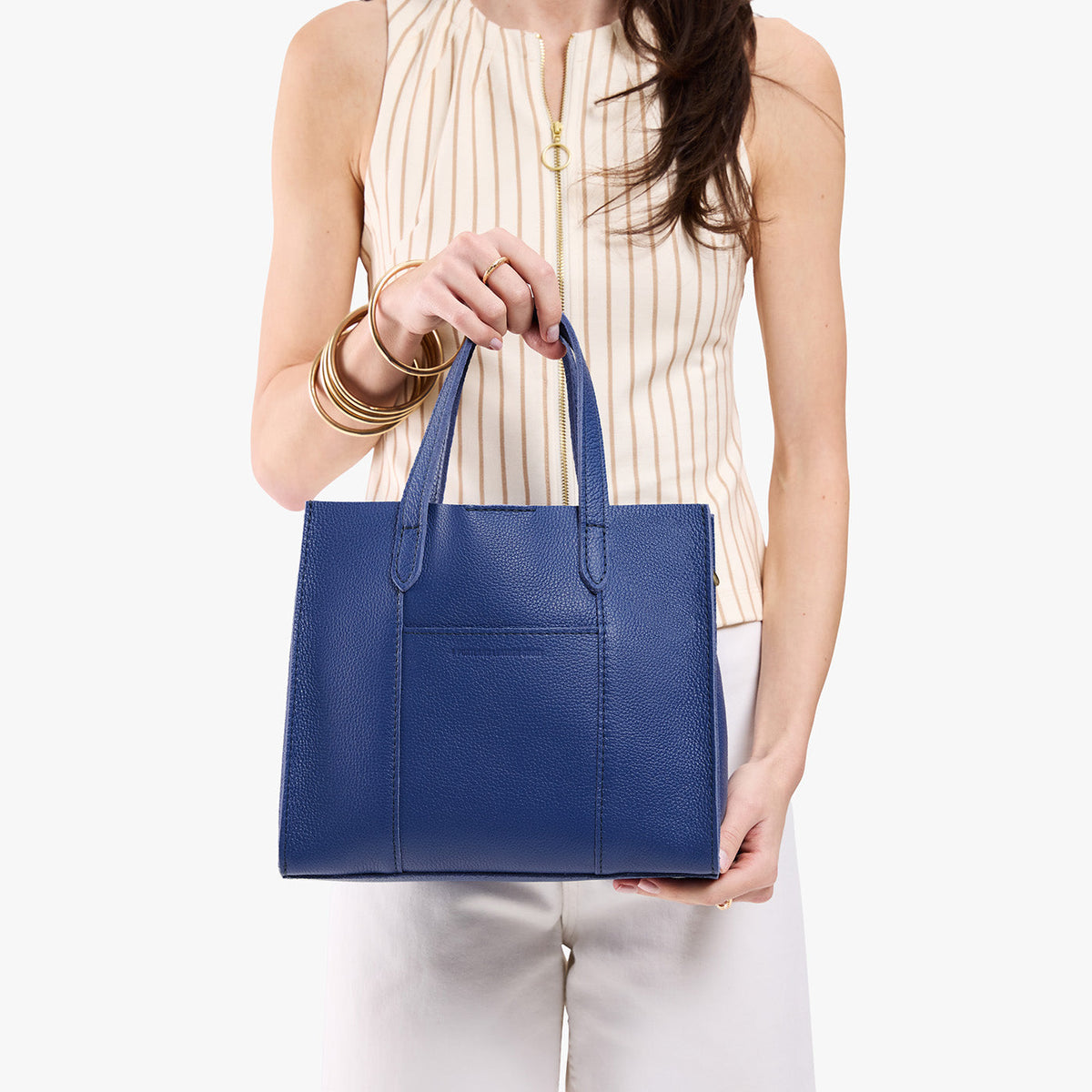 Molino Blue | Model holding structured mid-size tote bag with overlapping panels and crossbody strap