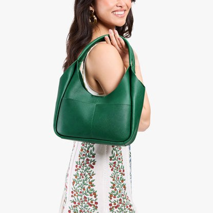 Bacalar*Medium | Model carrying U-shaped, flat-bottomed leather shoulder bag with two outside pockets