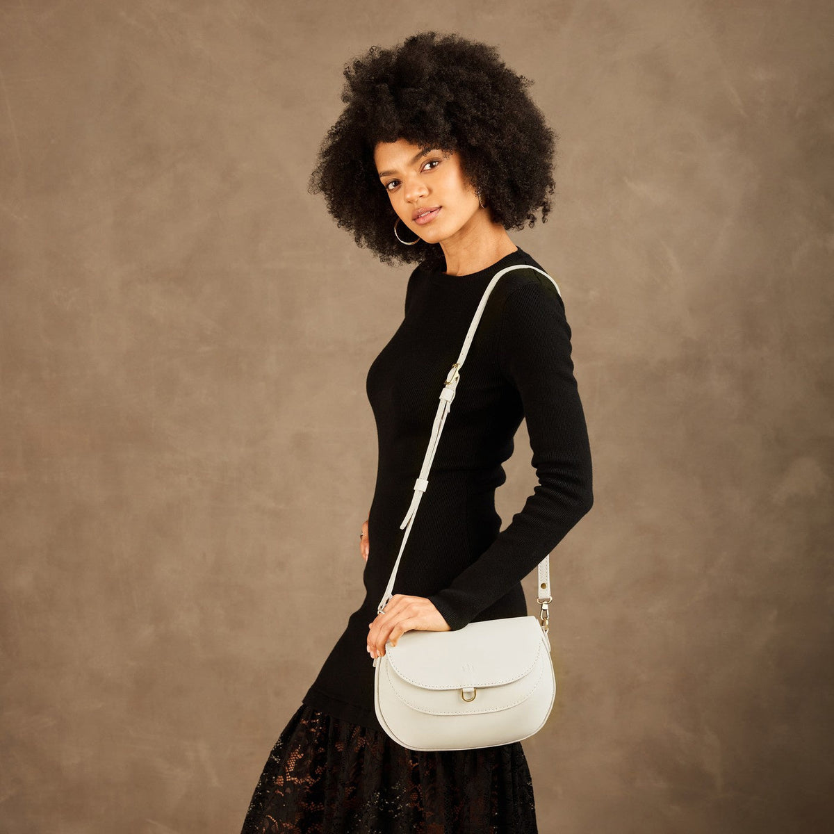 Bone*Large | Model wearing a leather Crossbody with a flap and magnetic closure
