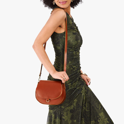 Madrone*Small | Model wearing a petite leather Crossbody with a flap and magnetic closure