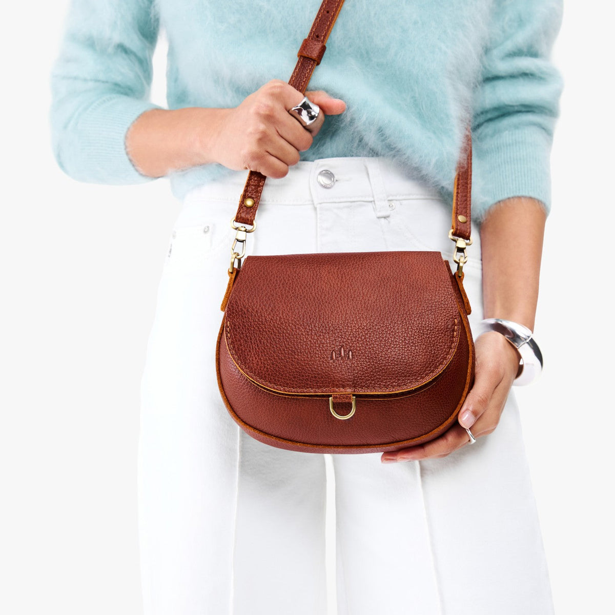 Nutmeg*Small | Model wearing a petite leather Crossbody with a flap and magnetic closure