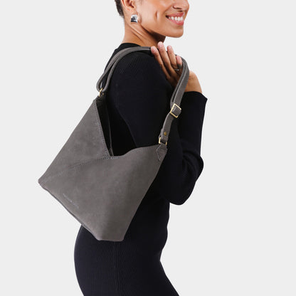 Smoke Grey*Small | Model wearing petite shoulder bag with adjustable strap and magnetic snap closure