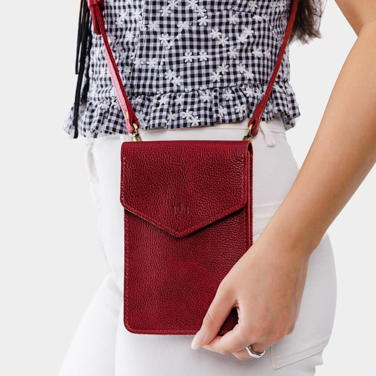 Chili Red | Model wearing slim, phone-shaped crossbody purse with magnetic closure