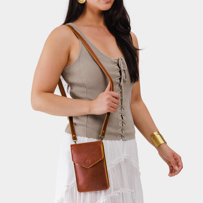 Nutmeg | Model wearing slim, phone-shaped crossbody purse with magnetic closure
