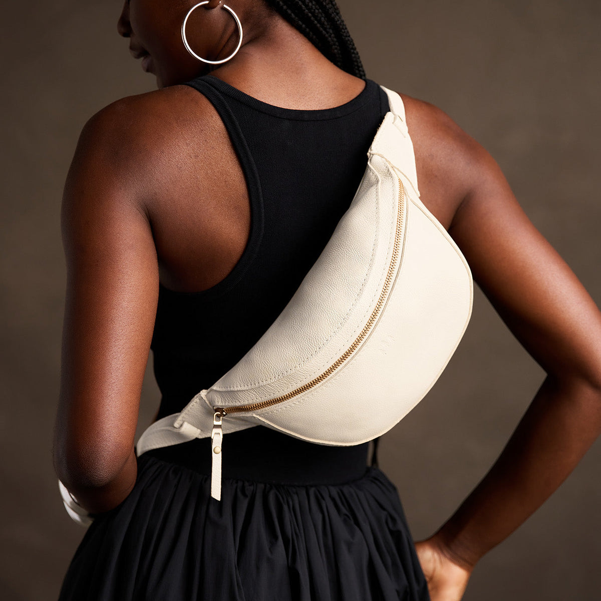 Pebbled Bone | Model wearing a sling bag with front zipper