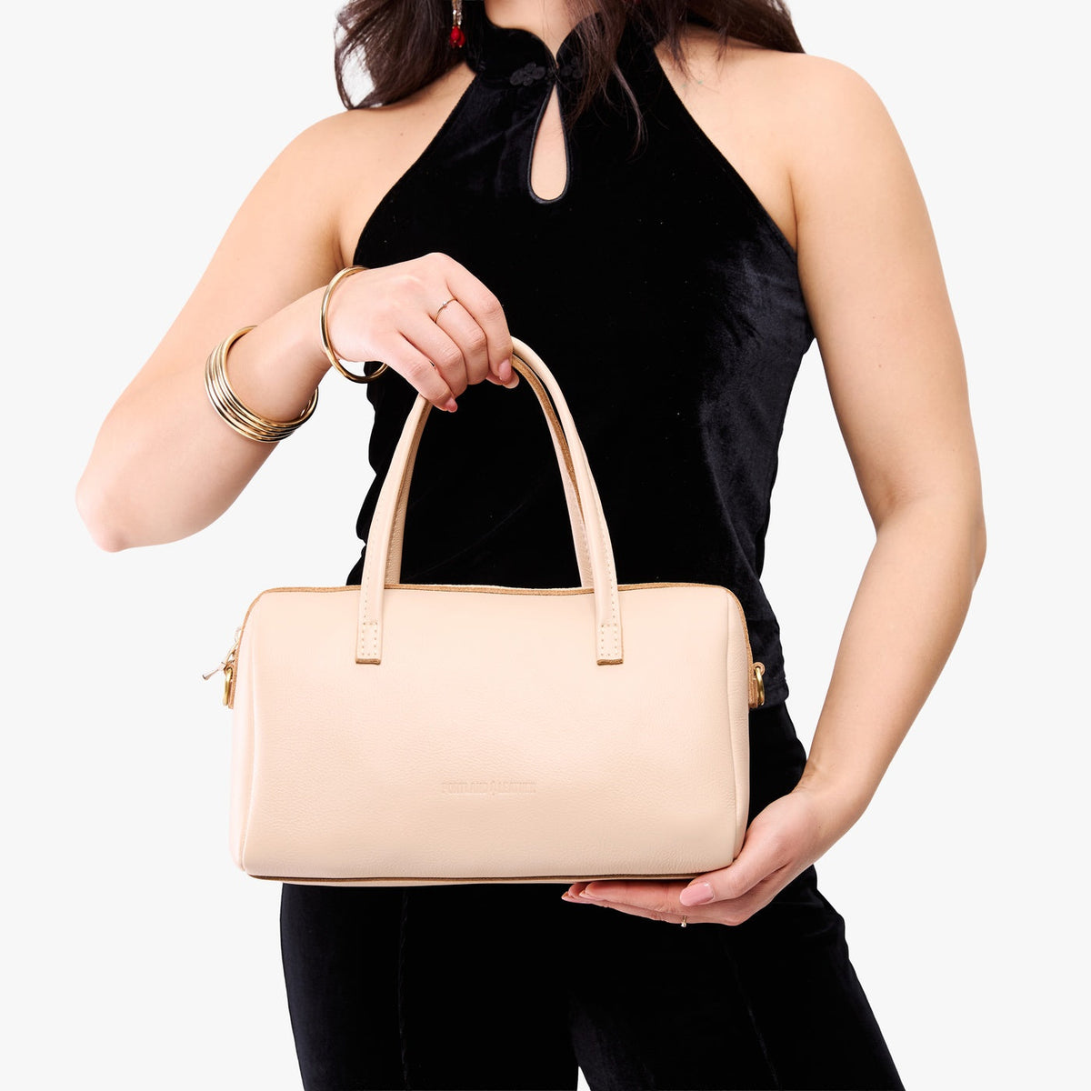 Moonflower*Oversized | Model holding mini duffle shaped handbag with crossbody strap