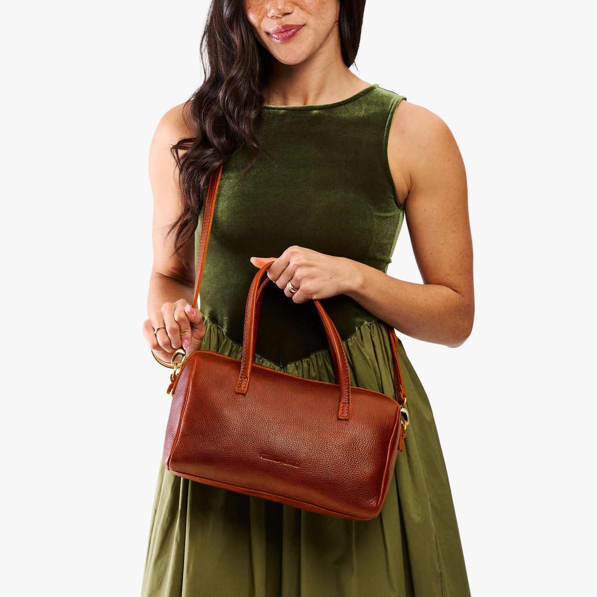 Nutmeg*Oversized | Model holding mini duffle shaped handbag with crossbody strap